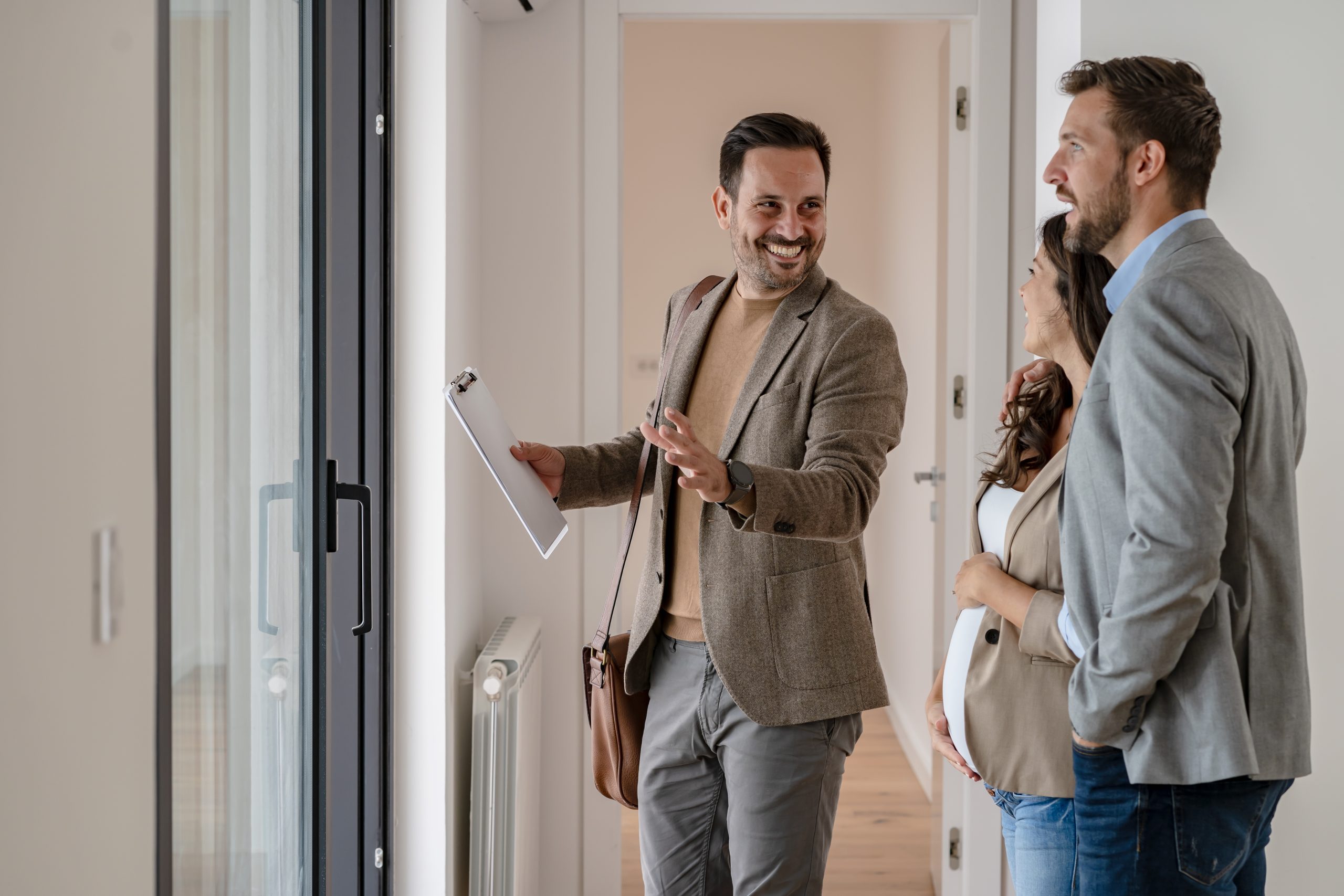 une personne qui fait visiter un appartement à un couple
